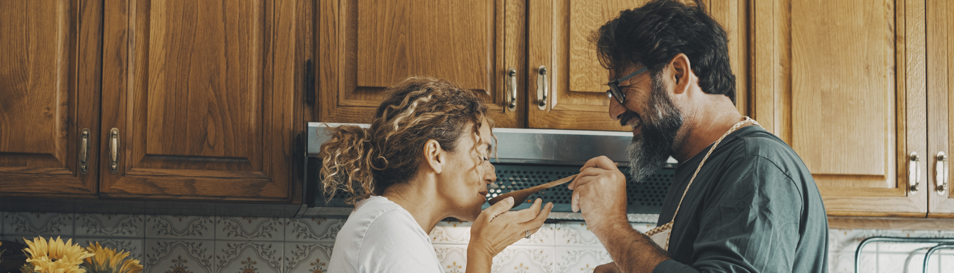 happy couple in kitchen tasting food